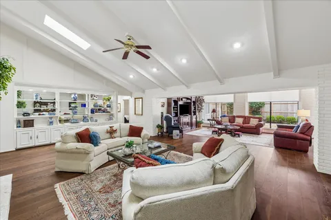 a living room with furniture a flat screen tv and a large window