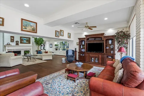 a living room with furniture fireplace and a large window