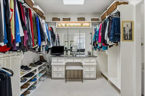 a view of walk in closet with clothes and shoes