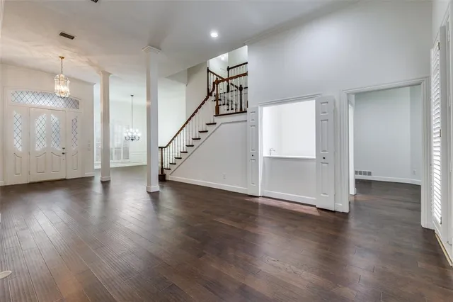 an empty room with wooden floor and staircase