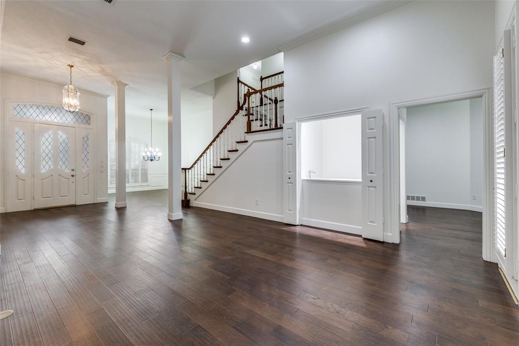 17101 Vista Tree Circle Dallas, TX 75248 - Photo 3 of 22 an empty room with wooden floor and staircase