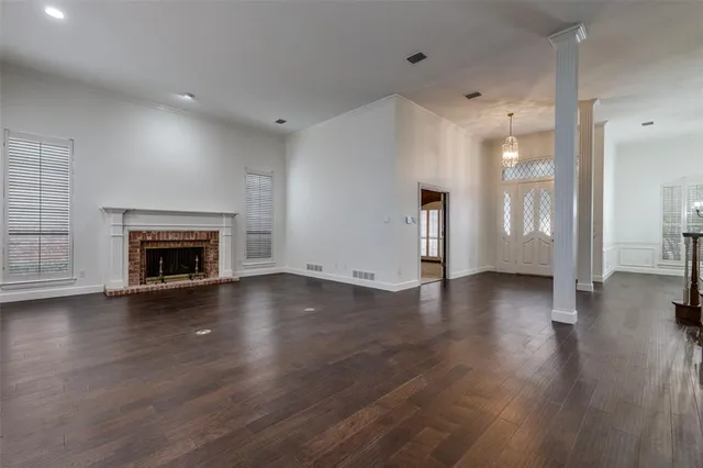 an empty room with wooden floor and fireplace
