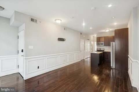 a view of kitchen with refrigerator microwave and wooden floor