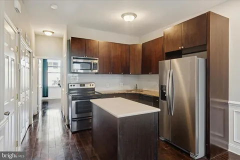 a kitchen with stainless steel appliances a refrigerator and a stove top oven