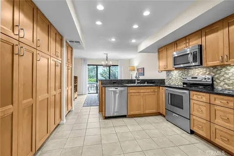 a kitchen with stainless steel appliances granite countertop a stove a sink and a microwave