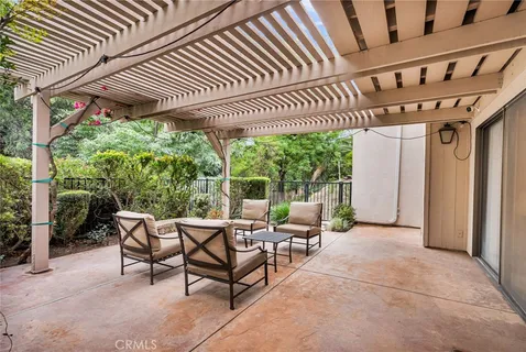 a patio with glass top table and chairs