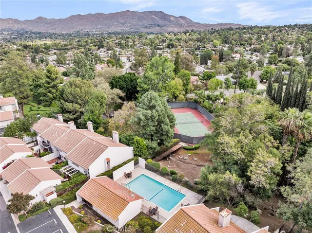 an aerial view of residential houses with outdoor space and trees