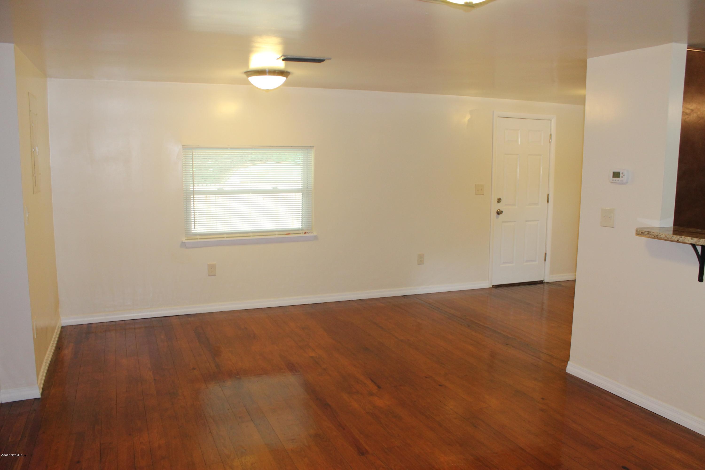 6207 Lone Star Road Jacksonville, FL 32211 - Photo 11 of 35 an empty room with wooden floor chandelier fan and windows