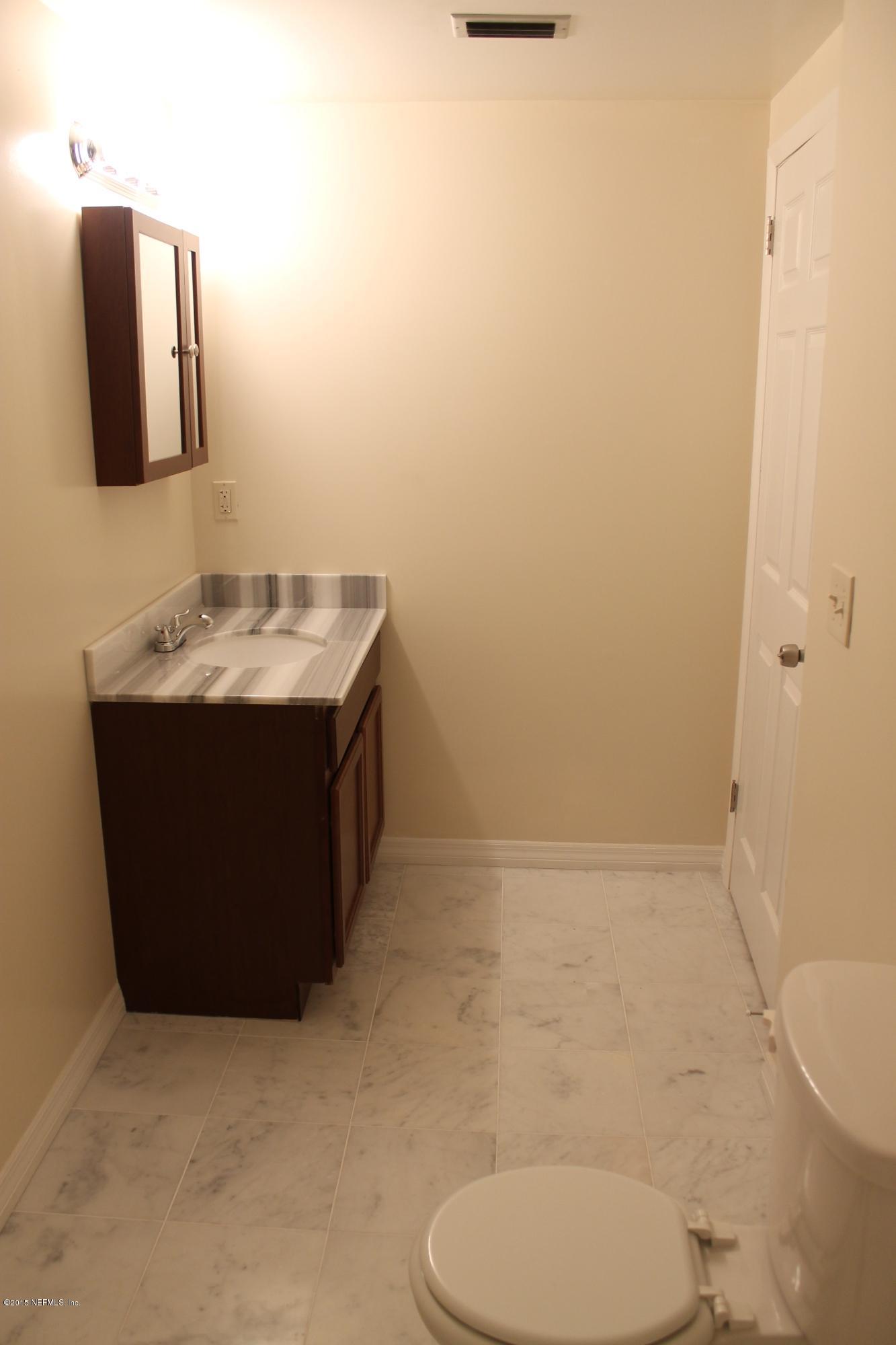 6207 Lone Star Road Jacksonville, FL 32211 - Photo 16 of 35 a bathroom with a toilet a sink and mirror
