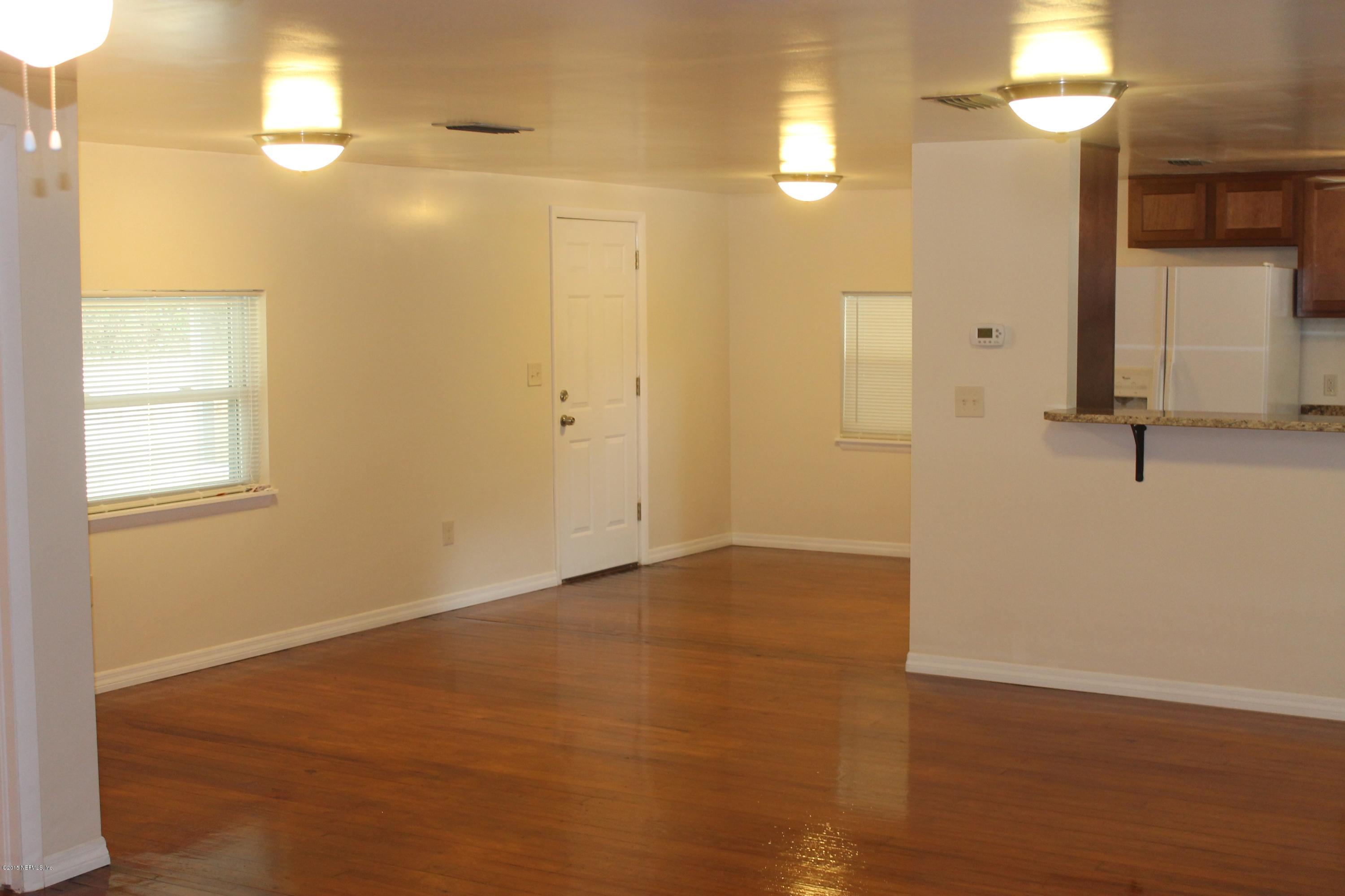 6207 Lone Star Road Jacksonville, FL 32211 - Photo 6 of 35 a view of an empty room with window and wooden floor