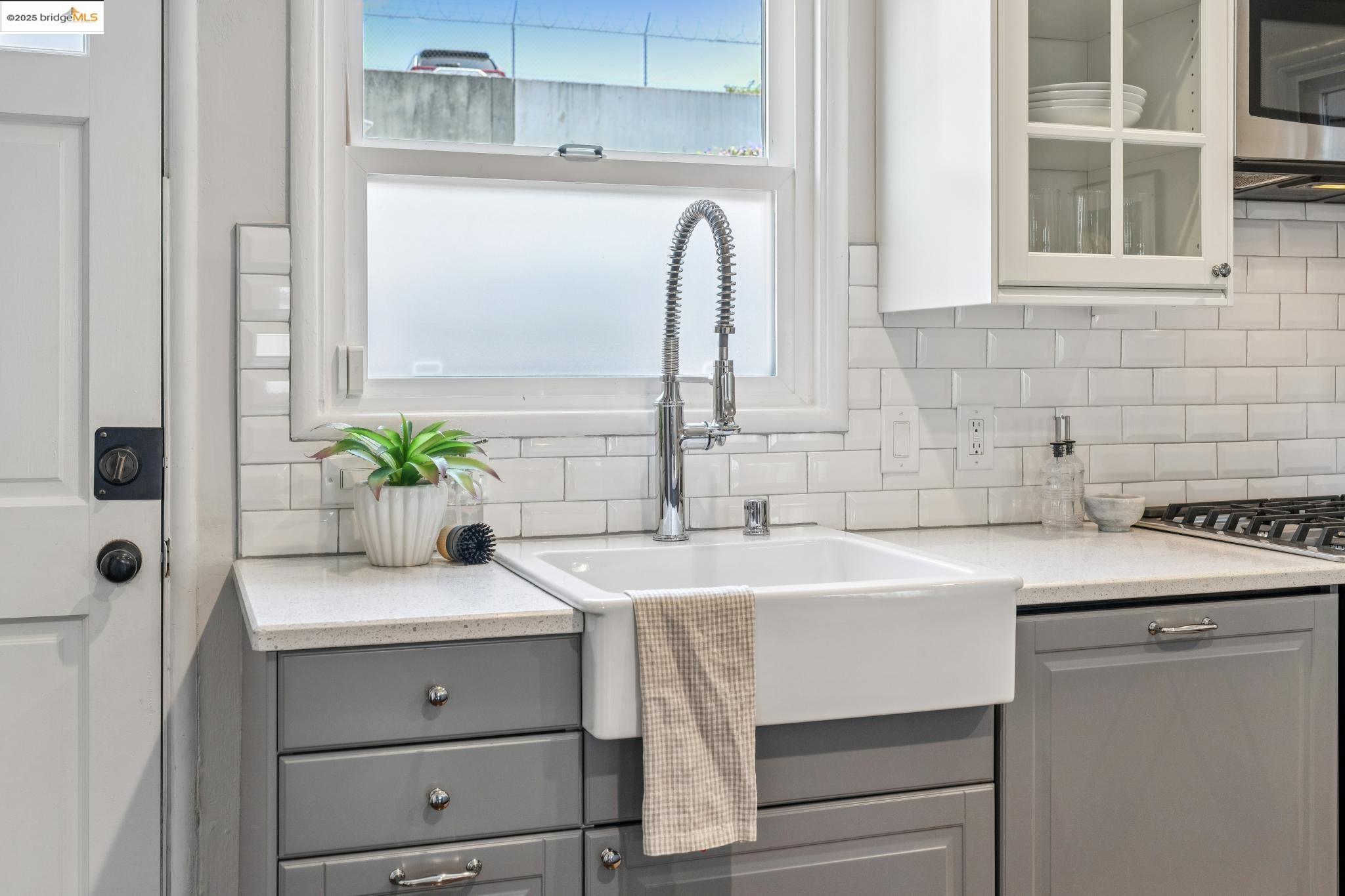 4170 Emerald Street, Unit 4 Oakland, CA 94609 - Photo 11 of 37 Kitchen with gray cabinetry, decorative backsplash, healthy amount of natural light, and stainless steel appliances