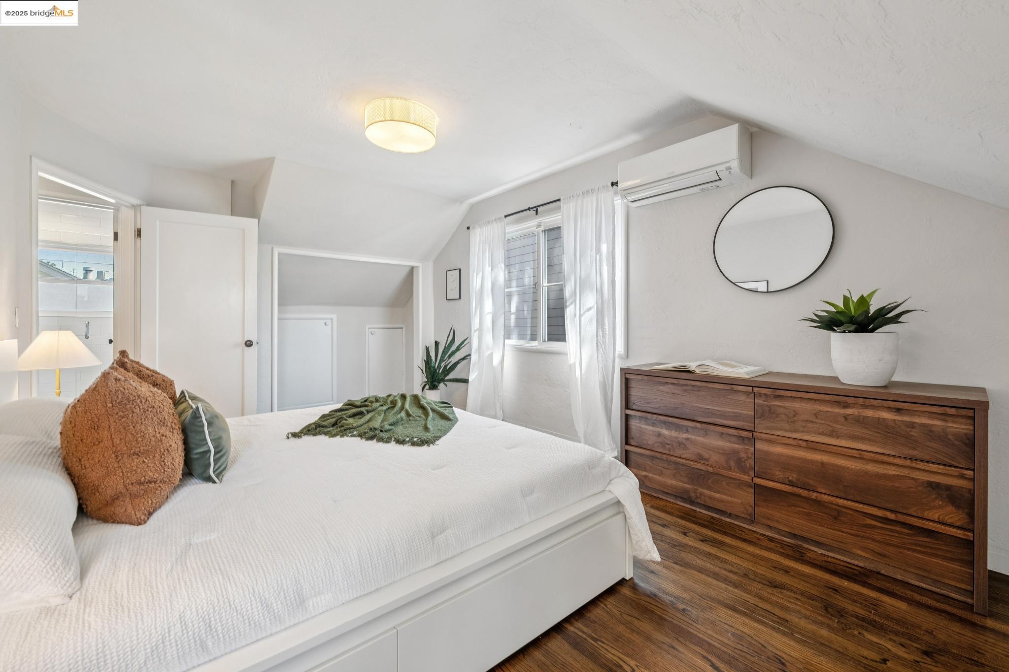 4170 Emerald Street, Unit 4 Oakland, CA 94609 - Photo 19 of 37 Bedroom with vaulted ceiling, wood finished floors, and an AC wall unit