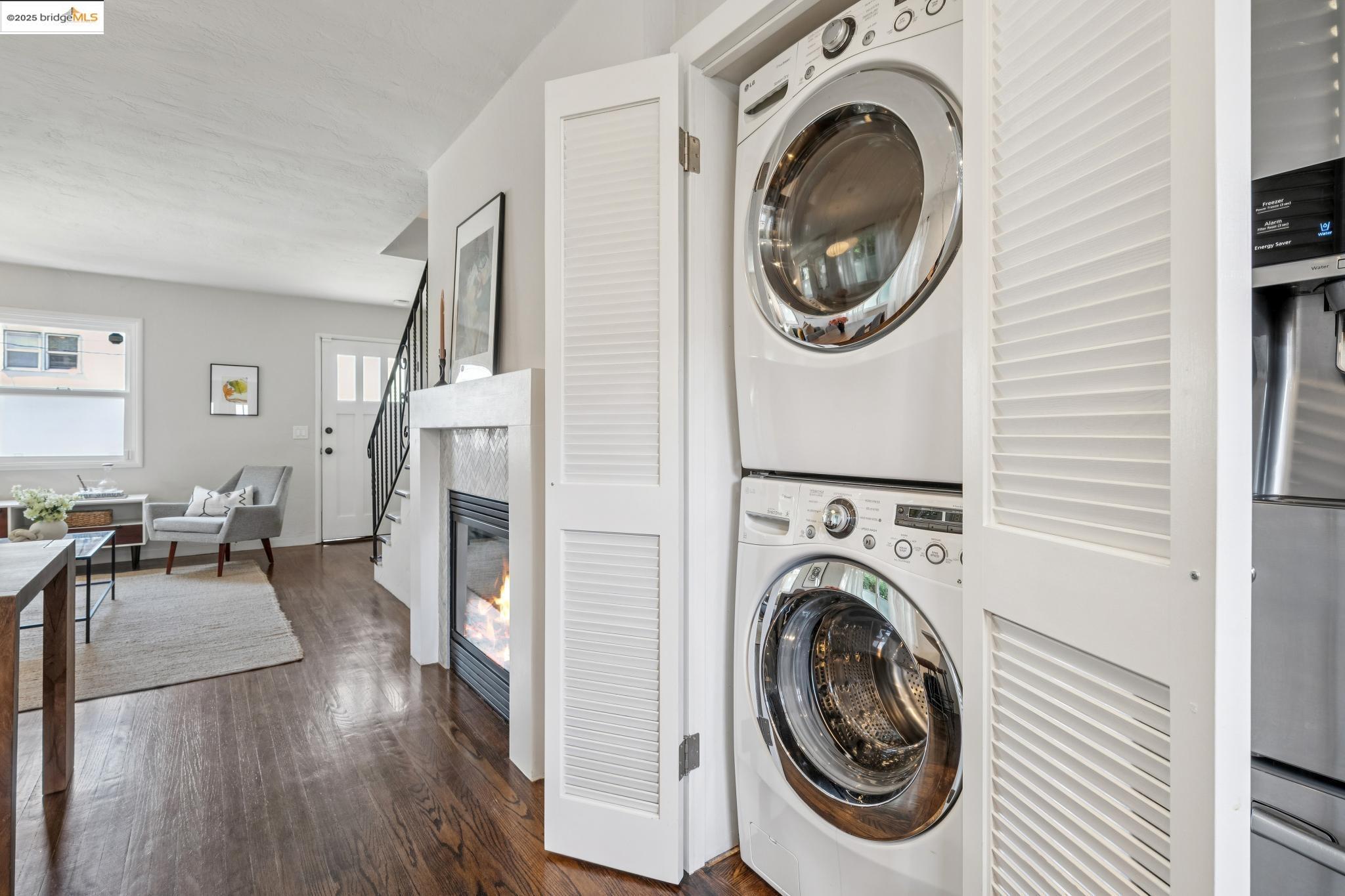 4170 Emerald Street, Unit 4 Oakland, CA 94609 - Photo 24 of 37 Laundry area with stacked washer and clothes dryer and dark wood finished floors