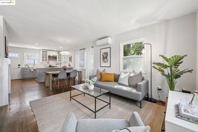 a living room with furniture kitchen view and a potted plant