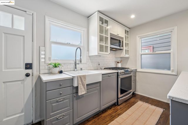 a kitchen with a sink cabinets stainless steel appliances and a window