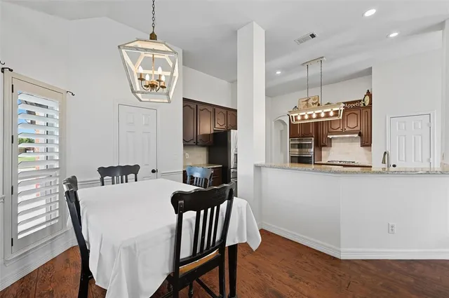 a view of a dining room with furniture a chandelier and wooden floor