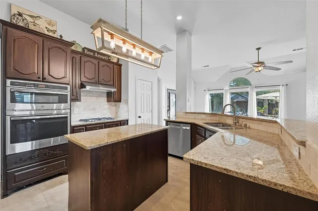 a kitchen with stainless steel appliances granite countertop a sink and stove