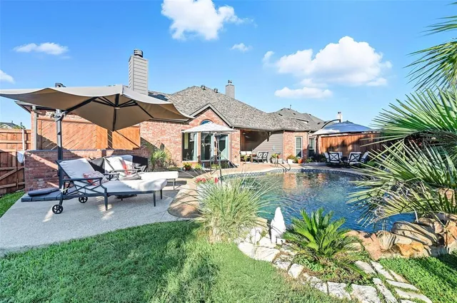 a view of a swimming pool with a table and chairs under an umbrella