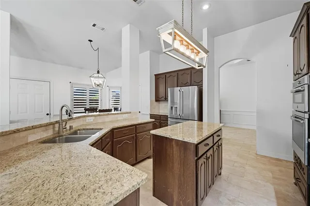 a kitchen with granite countertop a stove and a refrigerator