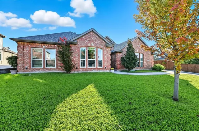 a front view of a house with a yard and trees