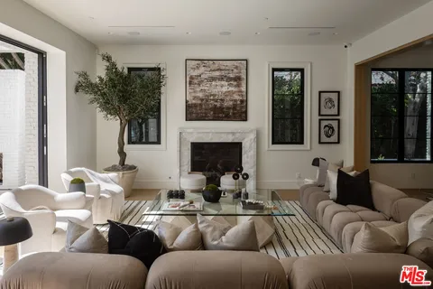 a living room with furniture a large window and a fireplace