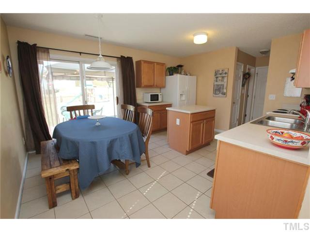 3812 Hopper Street Raleigh, NC 27616 - Photo 6 of 19 a kitchen with a stove a refrigerator and a dining table