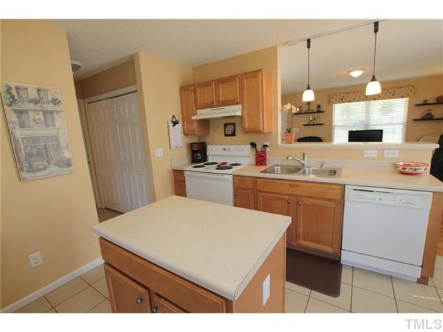 3812 Hopper Street Raleigh, NC 27616 - Photo 7 of 19 a kitchen with a sink a stove a refrigerator a center island and cabinets