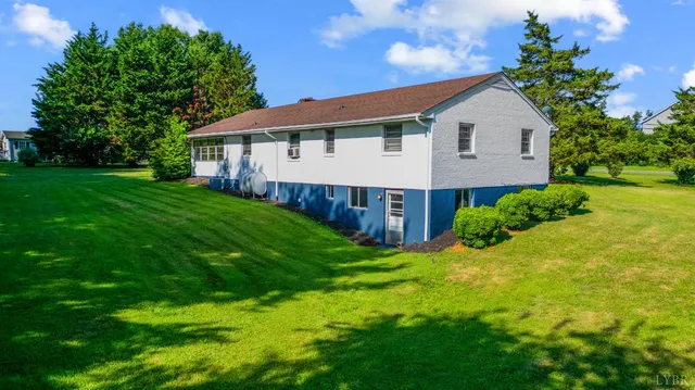 a view of a house with a yard and trees