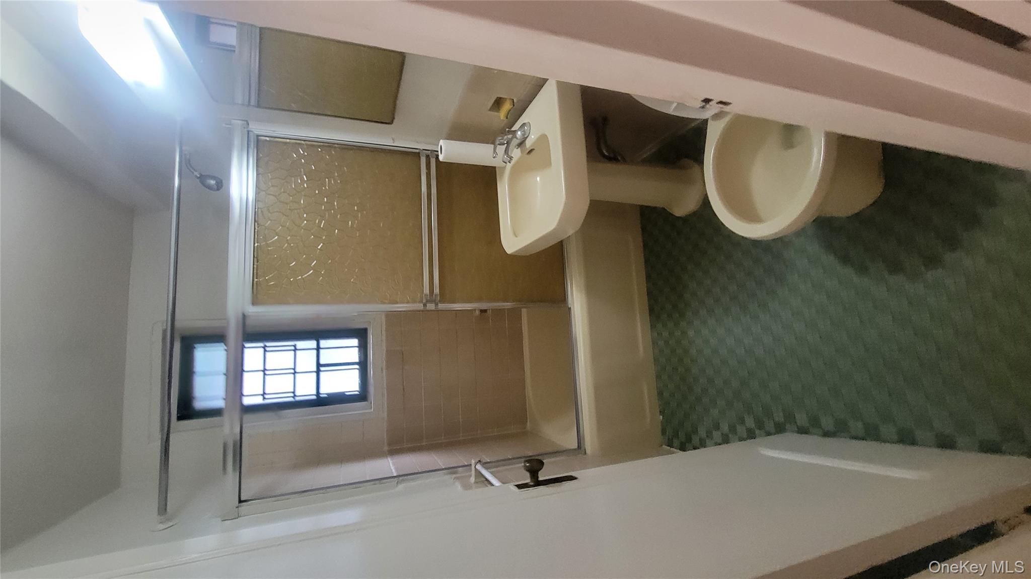 1596 Unionport Road, Unit 2E Bronx, NY 10462 - Photo 5 of 7 a white toilet sitting next to a bathroom sink and tub