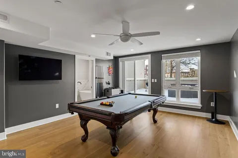 a room with furniture pool table flat screen tv and a large window