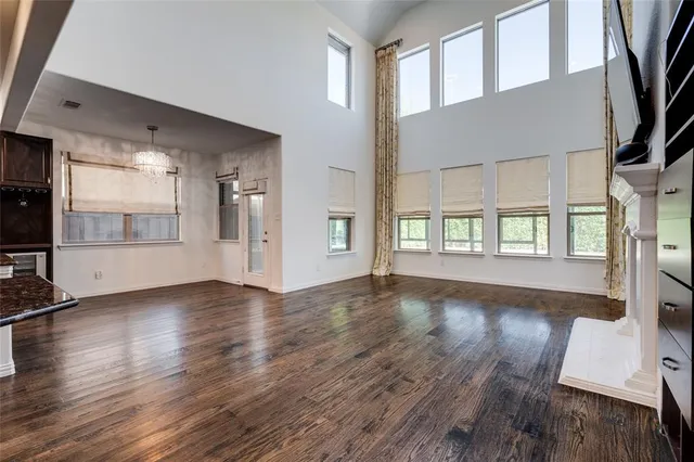 a view of a livingroom with a flat screen tv wooden floor and a ceiling fan