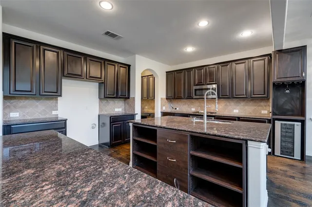 a kitchen with stainless steel appliances granite countertop a stove a sink and a refrigerator