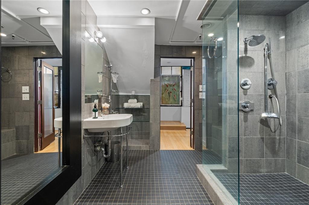 161 Mangum Street Southwest, Unit 102 Atlanta, GA 30313 - Photo 16 of 48 a bathroom with a sink shower and a mirror