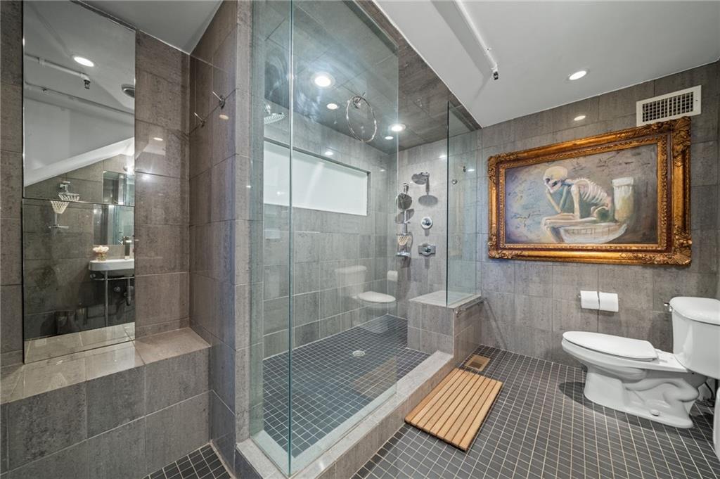 161 Mangum Street Southwest, Unit 102 Atlanta, GA 30313 - Photo 17 of 48 a bathroom with a toilet a sink and glass door shower