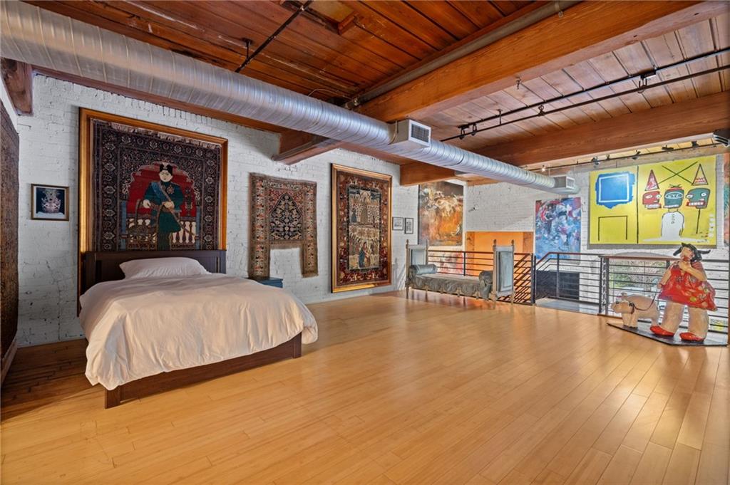 161 Mangum Street Southwest, Unit 102 Atlanta, GA 30313 - Photo 24 of 48 a spacious bedroom with a bed and wooden floor