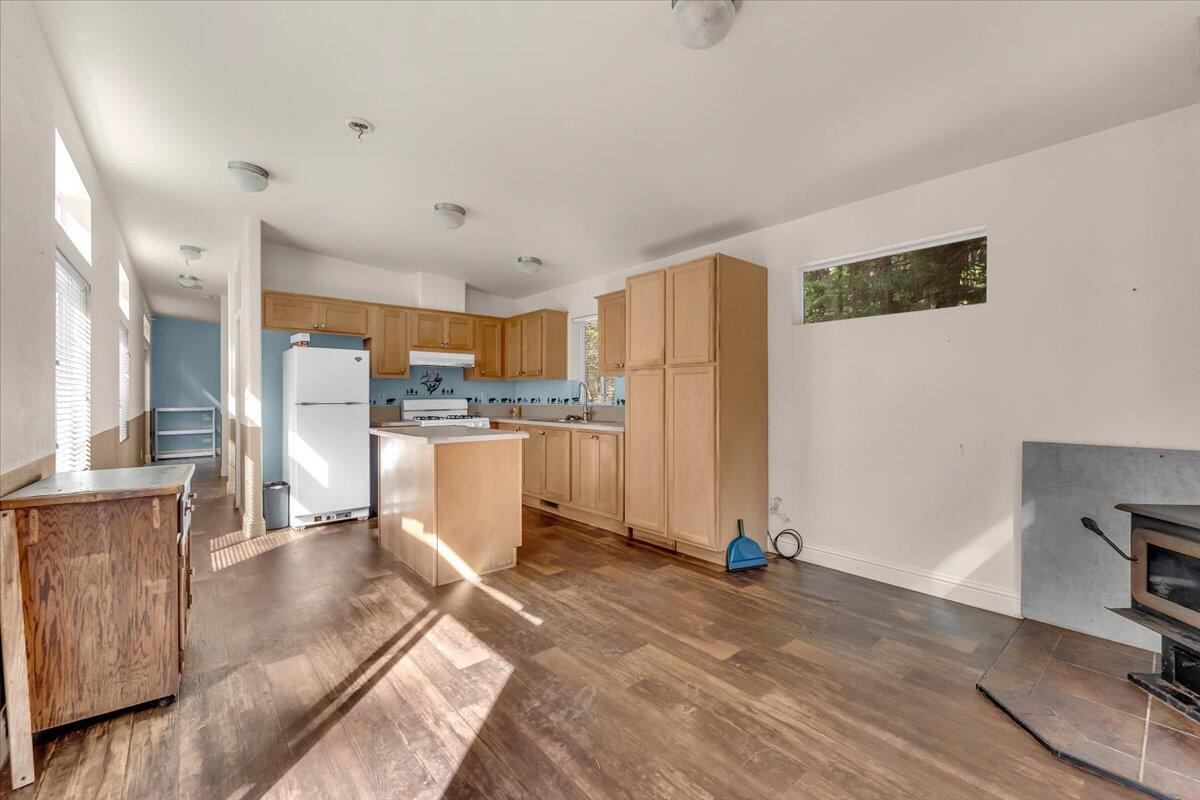 8495 Sky Tree Lane Shingletown, CA 96088 - Photo 11 of 55 a view of kitchen with stainless steel appliances kitchen island refrigerator stove and wooden floor