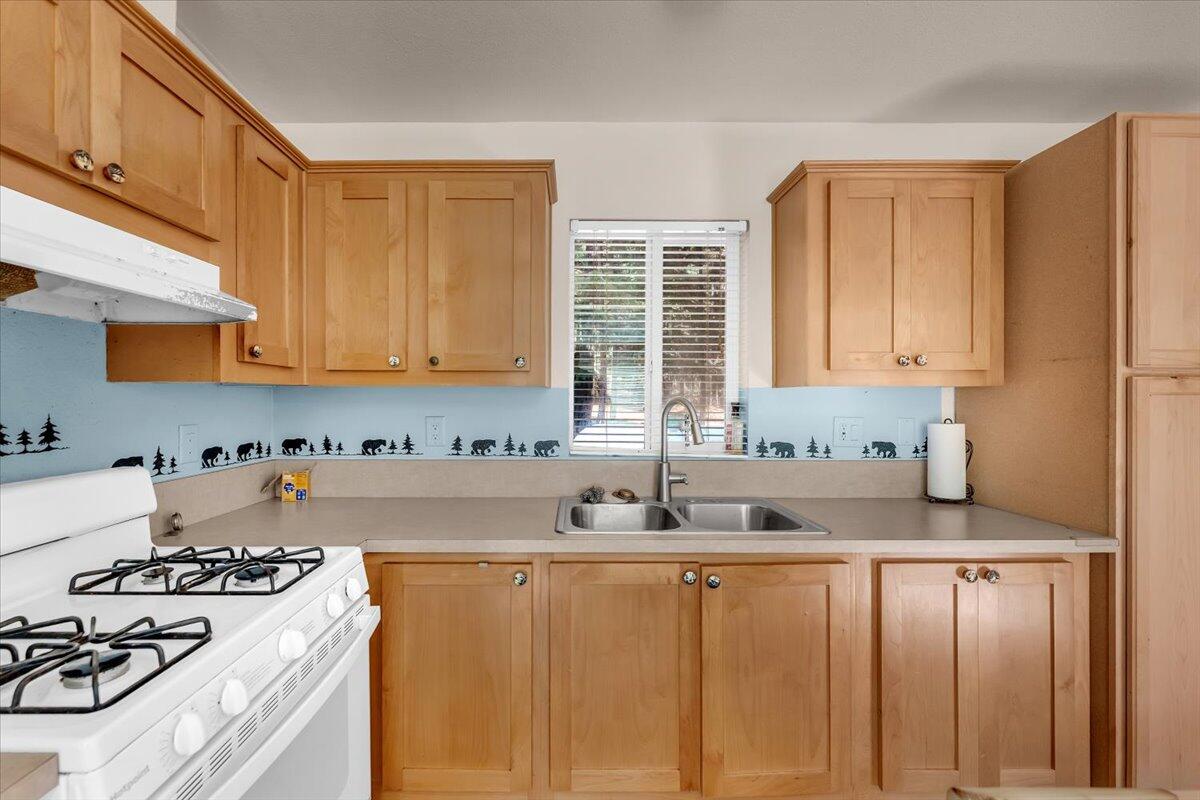 8495 Sky Tree Lane Shingletown, CA 96088 - Photo 16 of 55 a kitchen with stainless steel appliances a sink a stove a refrigerator and cabinets