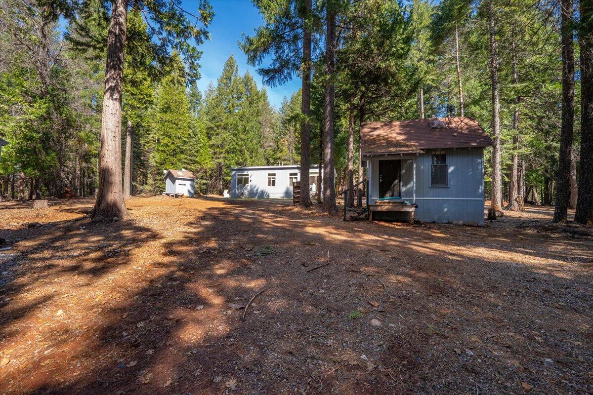 8495 Sky Tree Lane Shingletown, CA 96088 - Photo 35 of 55 a view of a house with large tree and wooden fence