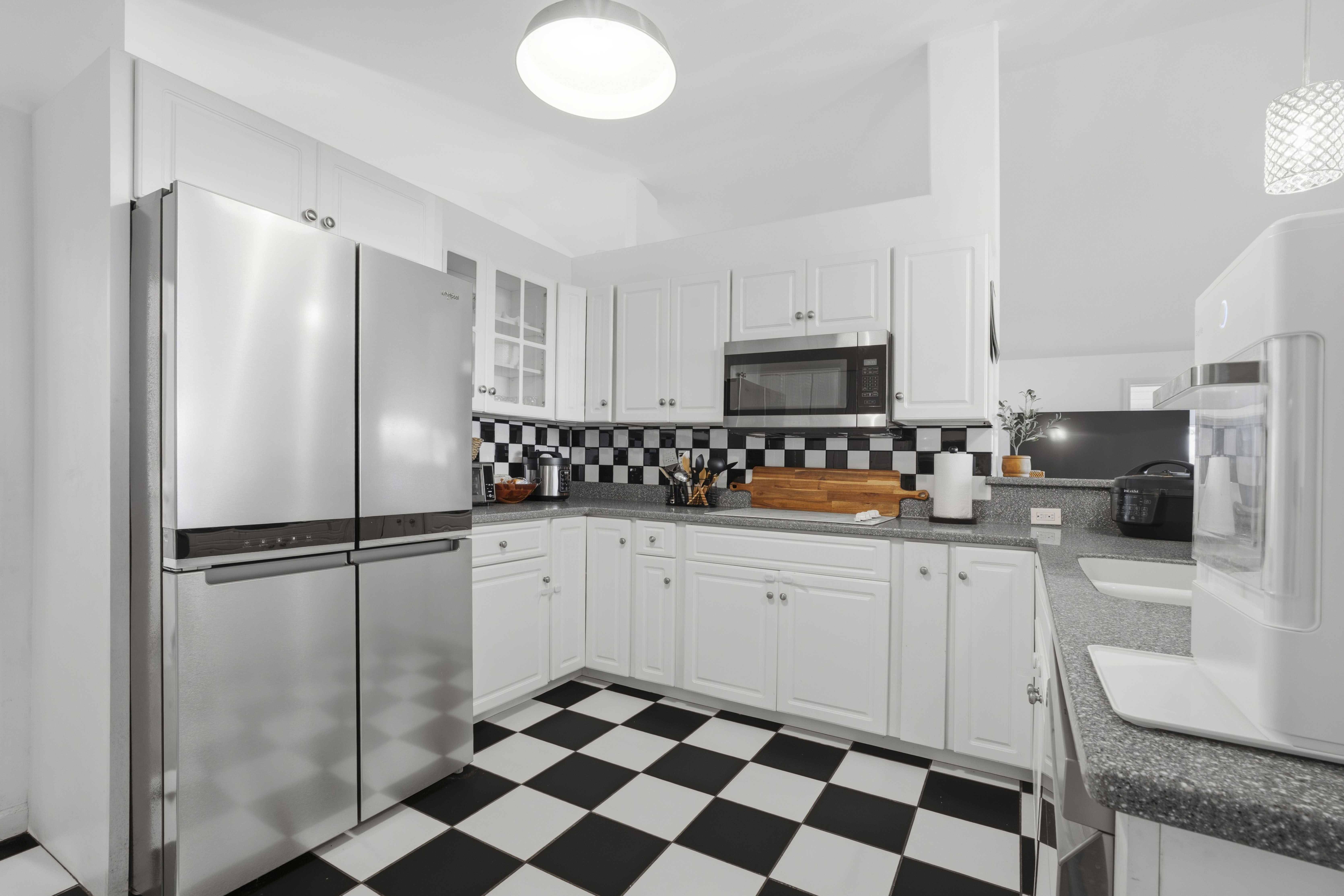 18-3970 Canney Road Mountain View, HI 96771 - Photo 11 of 30 a kitchen with a refrigerator a sink and white cabinets