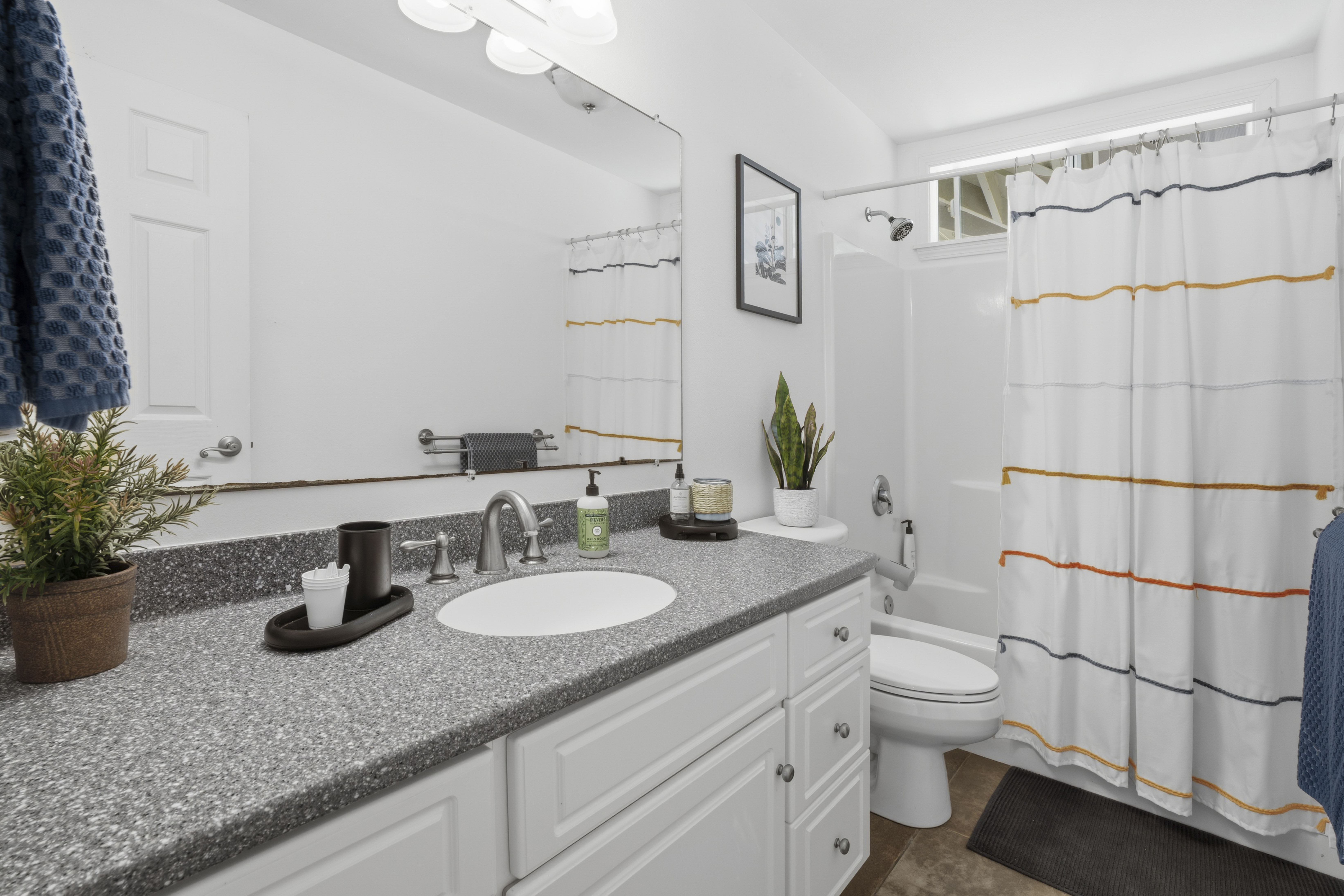 18-3970 Canney Road Mountain View, HI 96771 - Photo 19 of 30 a bathroom with a granite countertop sink a toilet a mirror a shower and vanity