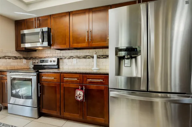 a kitchen with a refrigerator wooden cabinets and a stove