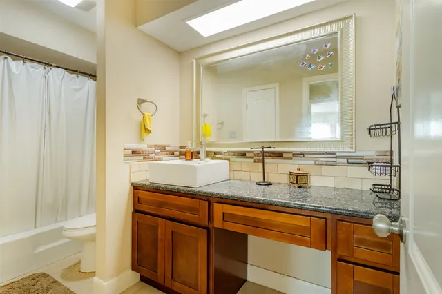 a patio with table and chairs and potted plants