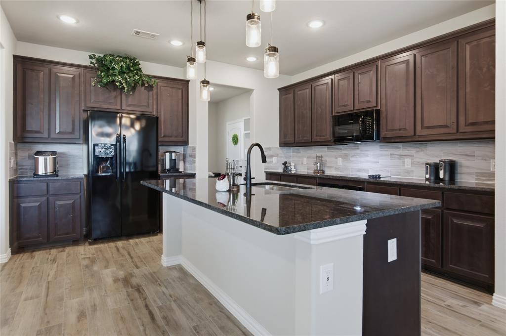 6343 Rustic Edge Street Godley, TX 76044 - Photo 14 of 37 Quartz countertops, modern lighting over the kitchen island