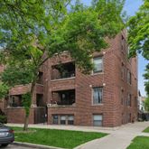 a front view of a house with a garden and tree