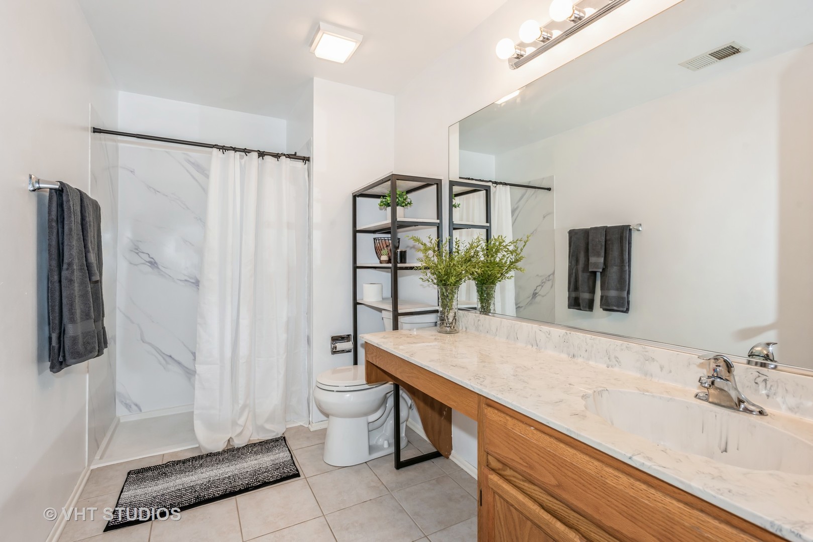 370 Ashford Circle, Unit 2 Bartlett, IL 60103 - Photo 9 of 13 a spacious bathroom with a granite countertop sink and a mirror