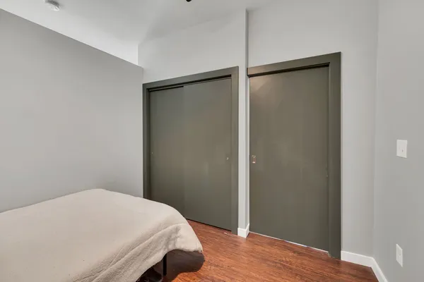 a bedroom with a bed and wooden floor