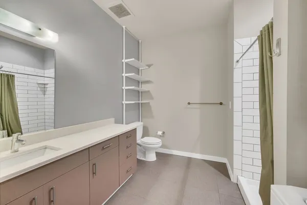 a bathroom with a double vanity sink toilet and shower