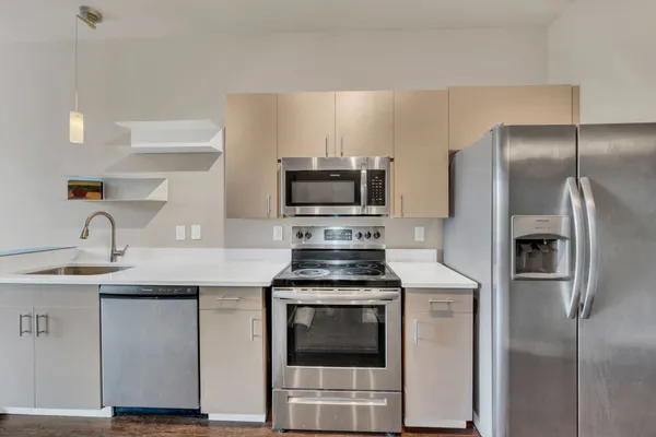 a kitchen with cabinets stainless steel appliances and a sink