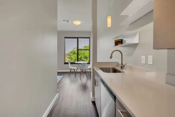 a kitchen with a sink cabinets and wooden floor