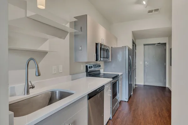 a kitchen with stainless steel appliances granite countertop a sink stove and refrigerator